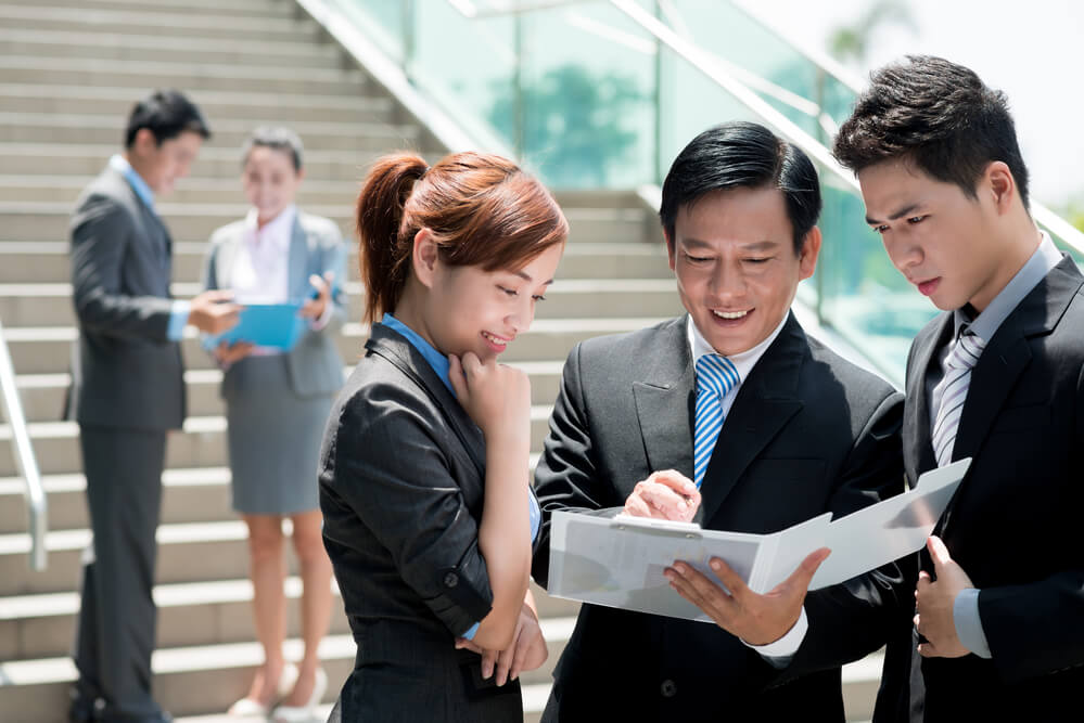 Vietnamese businesspeople having meeting outdoors