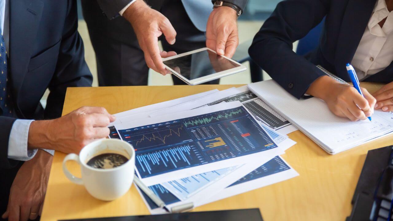 Unrecognizable business partners working with statistic charts